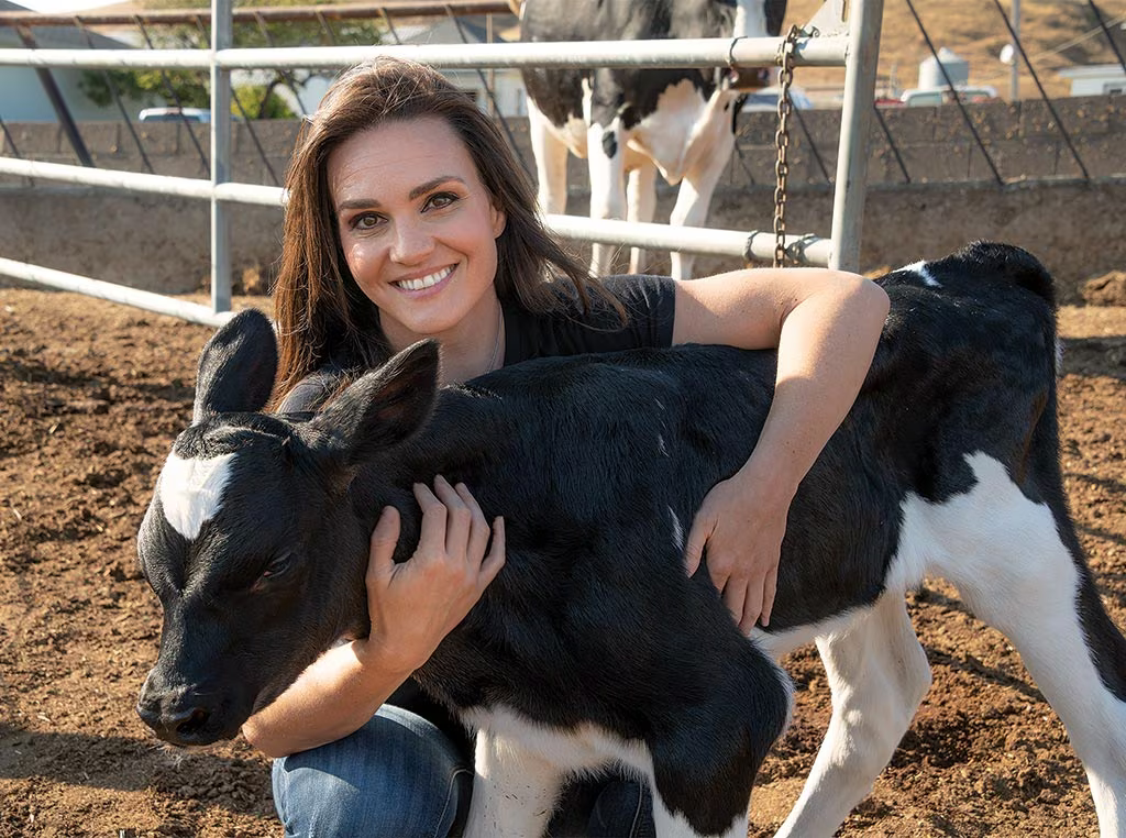 Shelina holding a baby Calf - John Deere article